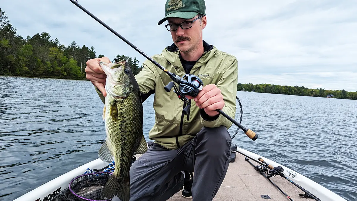 Hobie Wan Kenobi agenouillé sur un bateau avec une canne à basse et phenix avec un moulinet Daiwa Tatula BF TW 70