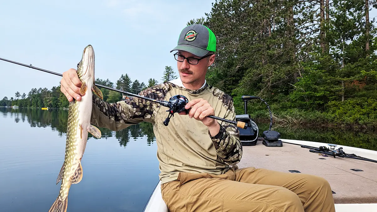 Hobie Wan Kenobi assis dans un bateau tenant un brochet et une canne avec le moulinet Daiwa Tatula BF TW 70