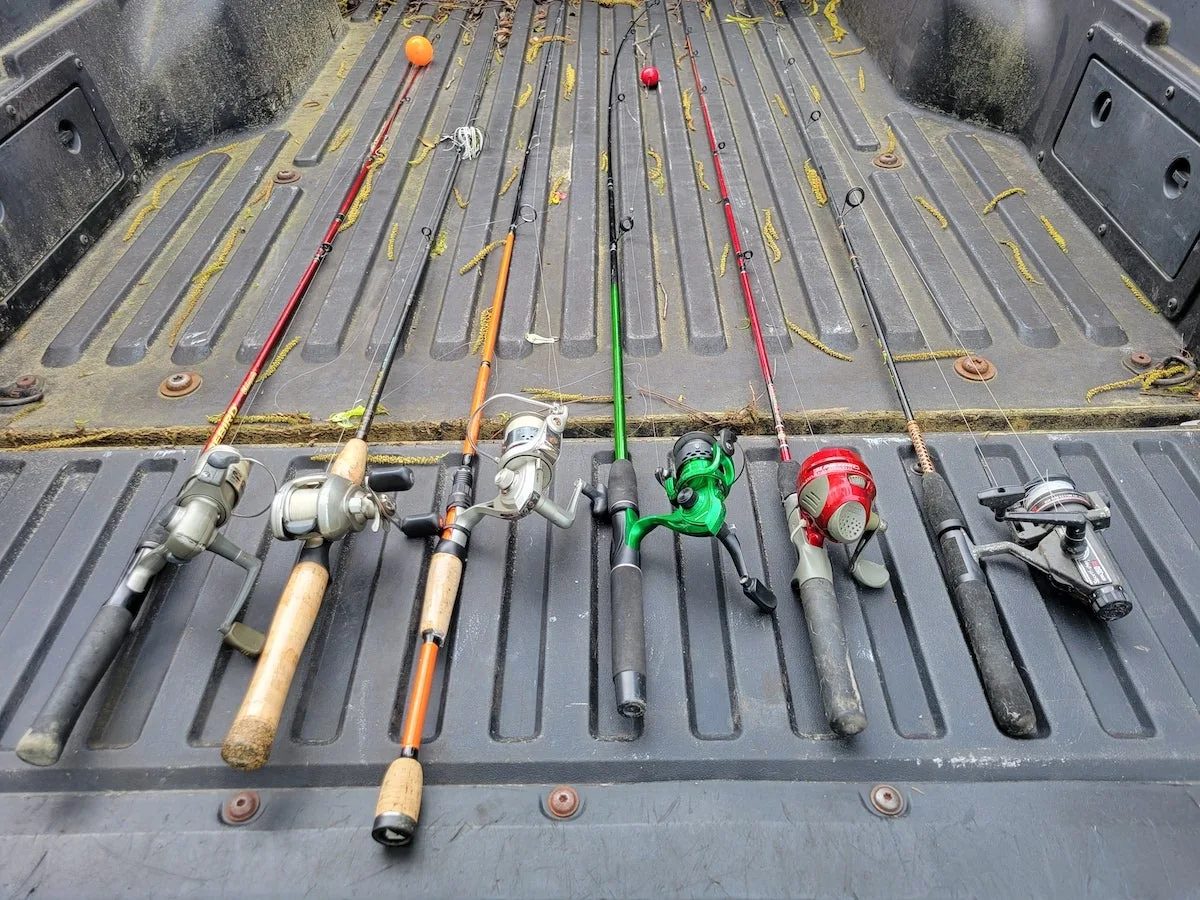 Des combinaisons de canne à pêche et de moulinet allongées sur un hayon de camion