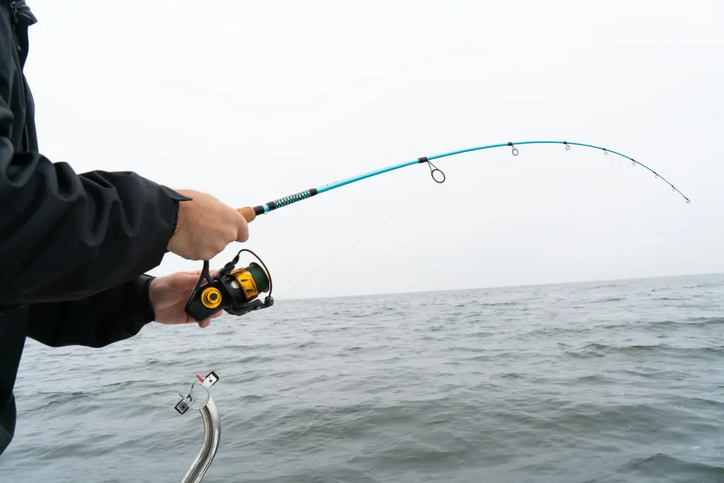 Une personne pêchant avec le vilain carbone Stik à côte à côte.