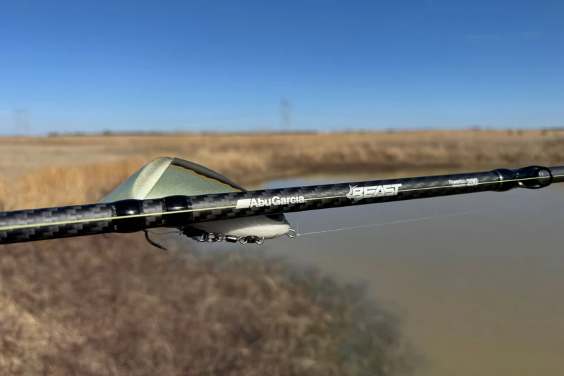 La canne combo Abu Garcia Beast montre un blank en fibre de carbone et une marque à proximité d'un leurre swimbait
