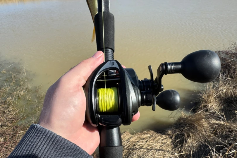 Le moulinet combo Beast est enroulé avec une ligne tressée brillante et maintenu au-dessus du rivage.