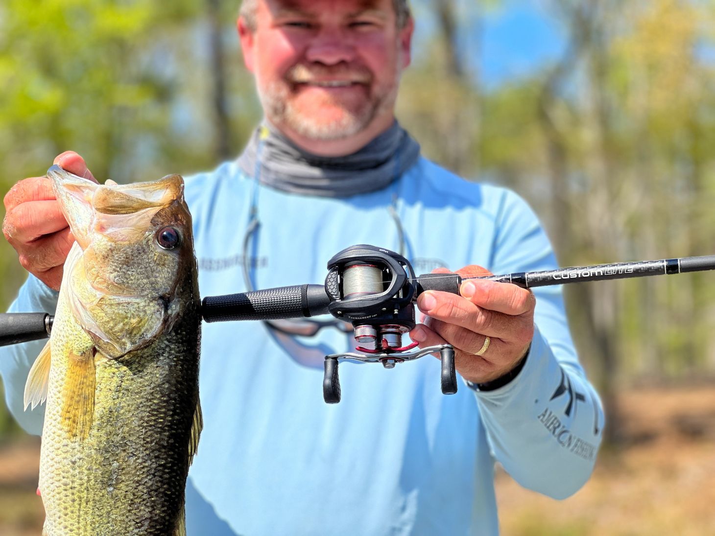 Pêcheur tenant l'achigan à grande bouche avec Lew's Rod